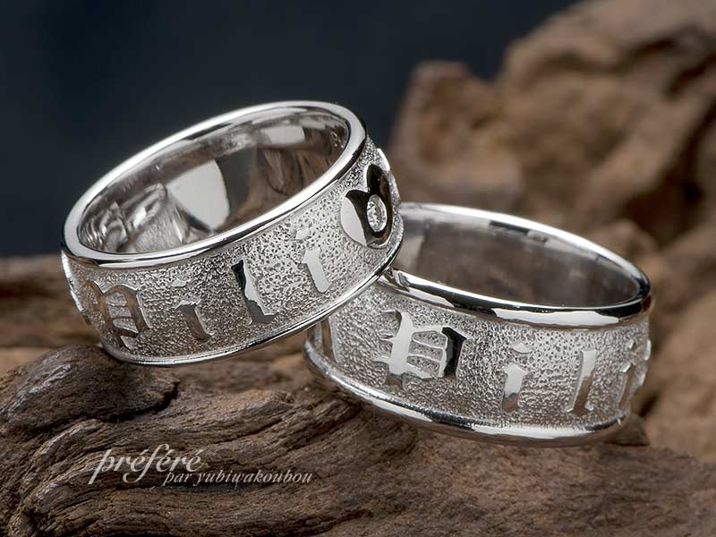 超幅広形状にイニシャルを全周にアレンジしたデザインのペアリングは結婚指輪